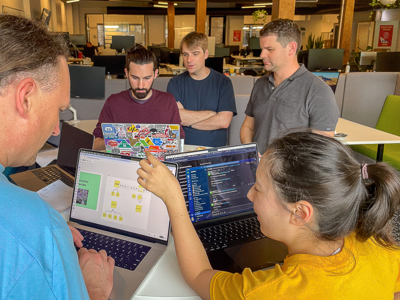 A team gathered around laptops during a workshop